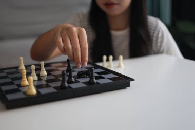 Evde birlikte satranç oynayan iki genç bayan arkadaş..