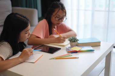 Masada ödev yapan iki kız öğrenci..