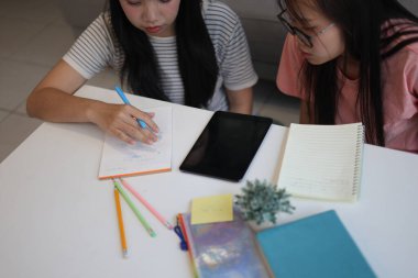 Masada ödev yapan iki kız öğrenci..