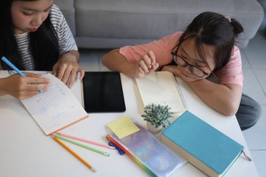 Masada ödev yapan iki kız öğrenci..