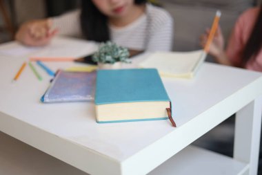 Masada ödev yapan iki kız öğrenci..