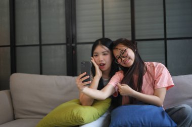 İki Asyalı bayan arkadaş içeride selfie çekiyor..