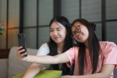 İki Asyalı bayan arkadaş içeride selfie çekiyor..