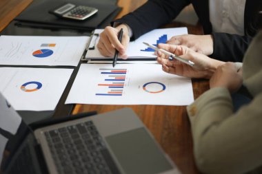 İş arkadaşları toplantı odasında belge raporlarını gözden geçiriyorlar.