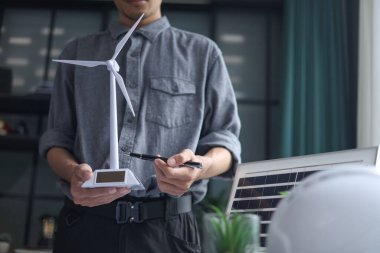 Mühendis yenilenebilir enerji sunar. Modern Ofis Çalışma Alanında Profesyonel Güneş Enerjili Rüzgar Türbininin Yakın Çekimi.