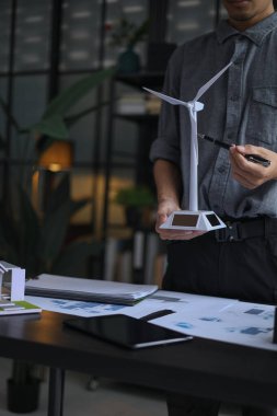 Mühendis yenilenebilir enerji sunar. Modern Ofis Çalışma Alanında Profesyonel Güneş Enerjili Rüzgar Türbininin Yakın Çekimi.