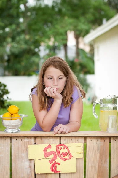 Gelangweilte junge Frau ohne Kunden an ihrem Limonadenstand — Stockfoto