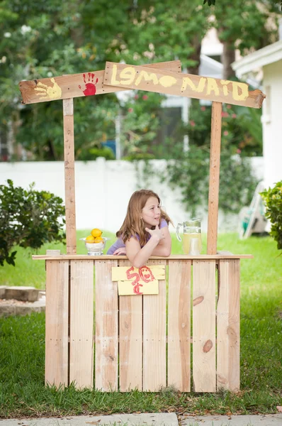 A bored young girl with no customers at her lemonade stand — 图库照片