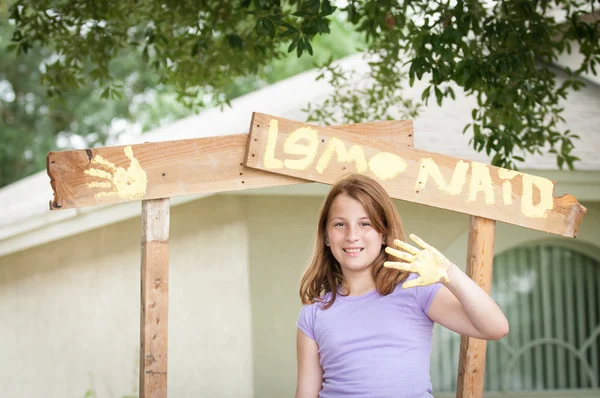 Young girl painting lemonade stand — Stock Photo, Image