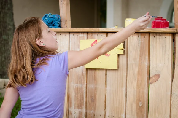 Young girl painting lemonade stand — Stock Photo, Image