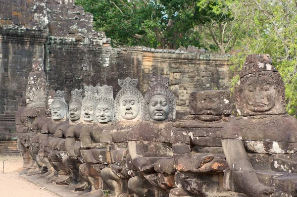 Asuras (Demons) statues in a row at the south entrance gate of the Bayon Temple in Siem Reap, Cambodia