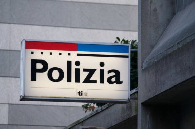 Lugano, Ticino, Switzerland - 7th January 2020 : Luminous Cantonal Police (Polizia) station sign of the Canton Ticino hanging on a building in Lugano, Switzerland clipart