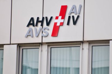 Zug, Switzerland - 26th February 2021 : AHV AVS IV AI Swiss pension and invalidity social insurance logo hanging on the office building in Zug, Switzerland clipart
