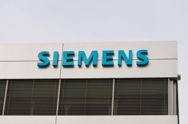 Zug, İsviçre - 26 Şubat 2021: İsviçre 'nin Zug kentindeki bir binanın cephesinde asılı Siemens şirketi tabelası. Siemens AG uluslararası ve Avrupa 'nın en büyük mühendislik şirketlerinden biri.