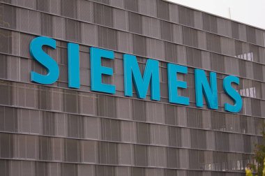 Zug, İsviçre - 26 Şubat 2021: İsviçre 'nin Zug kentindeki bir binanın cephesinde asılı Siemens şirketi tabelası. Siemens AG uluslararası ve Avrupa 'nın en büyük mühendislik şirketlerinden biri.