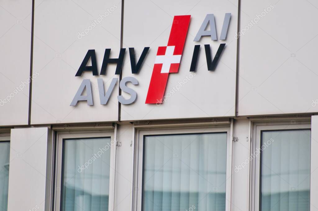 Zug, Switzerland - 26th February 2021 : AHV AVS IV AI Swiss pension and invalidity social insurance logo hanging on the office building in Zug, Switzerland