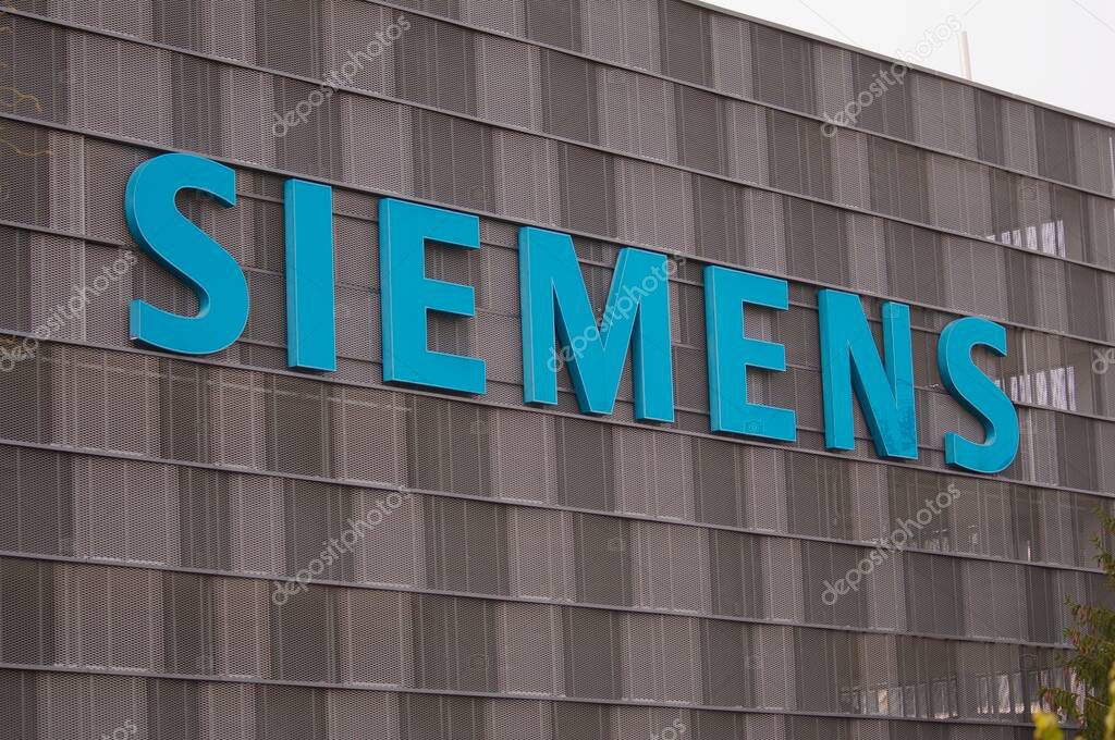 Zug, Switzerland - 26th February 2021 : Siemens company sign hanging on a building facade in Zug, Switzerland. Siemens AG is a international and one of the largest engineering company in europe