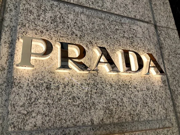 Lugano, Ticino, İsviçre - 10 Mart 2021: Lugano 'daki mağaza duvarında ışıklı Prada tabelası asılı. Prada, uluslararası bir İtalyan lüks giyim şirketi.