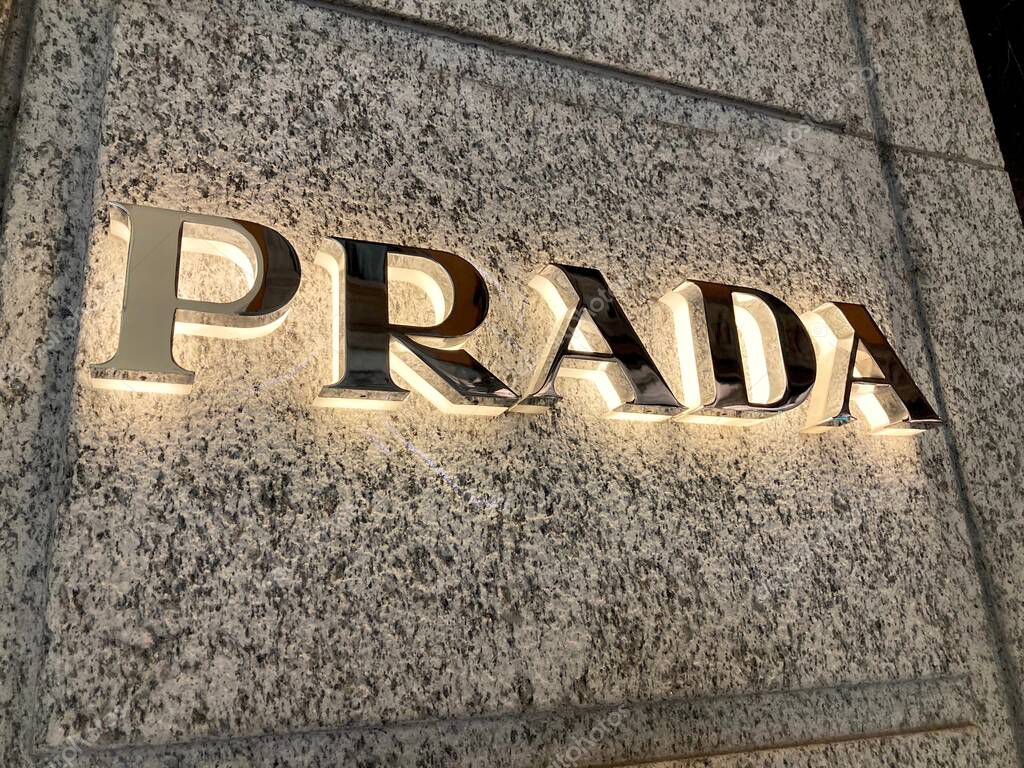 Lugano, Ticino, Switzerland - 10th March 2021 : Illuminated Prada sign hanging on the store wall in Lugano. Prada is a international italian luxury clothing company