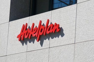 Lugano, Ticino, İsviçre - 24 Mart 2021: Güneşle aydınlatılan otel planı tabelası ve İsviçre 'nin Lugano kentindeki bir binada asılı duruyor. Otel planı İsviçre 'nin en büyük seyahat acentelerinden biridir.