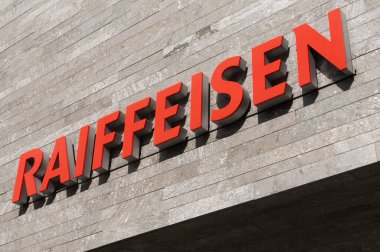 Wohlen, Aargau, İsviçre - 15 Nisan 2021: İsviçre Raiffeisen bankası Wohlen 'deki bir beton cephede. Raiffeisen bir İsviçre kooperatif bankası, İsviçre 'deki en büyük üçüncü banka.