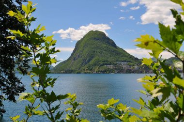 Güzel Monte San Salvatore (San Salvatore Dağı olarak da bilinir) ve güneşli bir günde Lugano Gölü manzarası