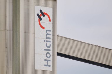 Siggenthal, Aargau, İsviçre - 18 Nisan 2021: İsviçre 'de bir binanın önünde Holcim şirketi tabelası asılı. Holcim, İsviçre merkezli küresel bir inşaat malzemesi ve toplamlar şirketidir.