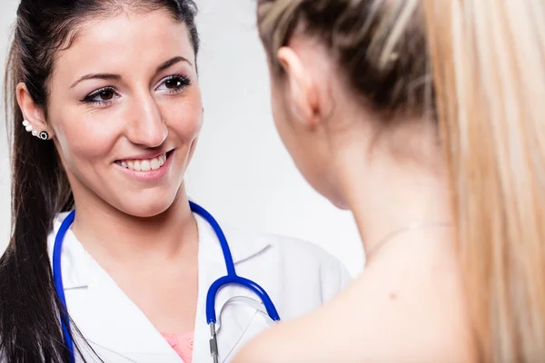 Ärztin lächelt ihren Patienten an — Stockfoto