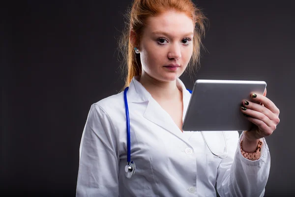 Médico ruivo segurando um comprimido — Fotografia de Stock