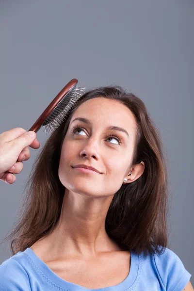 Vrouw kam met een haarborstel — Stockfoto