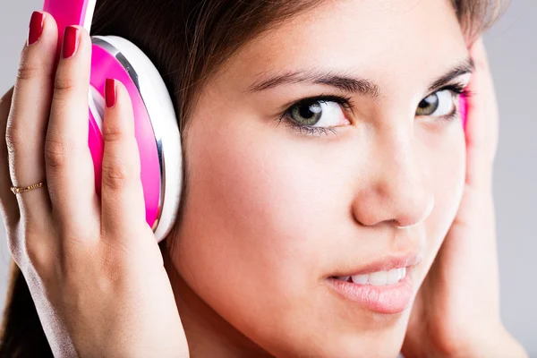 Pink headphones and beautiful eyes of a woman — Stock Photo, Image