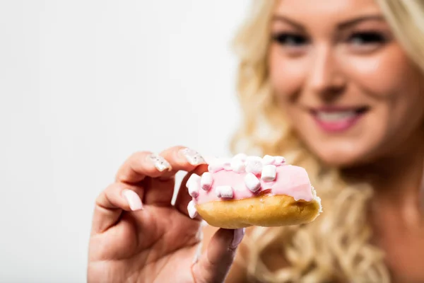 Donut i fokus med suddiga kvinna i bakgrunden — Stockfoto