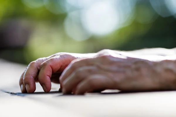 Yaşlı bir kadının bir tabloda kırışmış eller — Stok fotoğraf