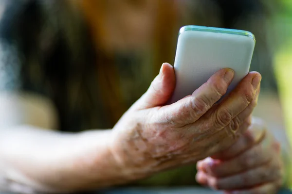 Eski bir cep telefonu tutan kadın — Stok fotoğraf