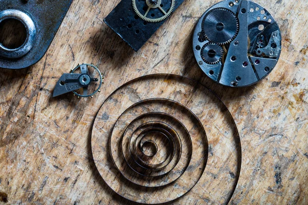 Spring, balance wheel and clockworks on a table — Stock Photo, Image