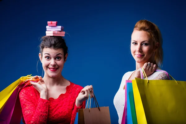 Frauen shoppen mit vielen Taschen auf blau — Stockfoto