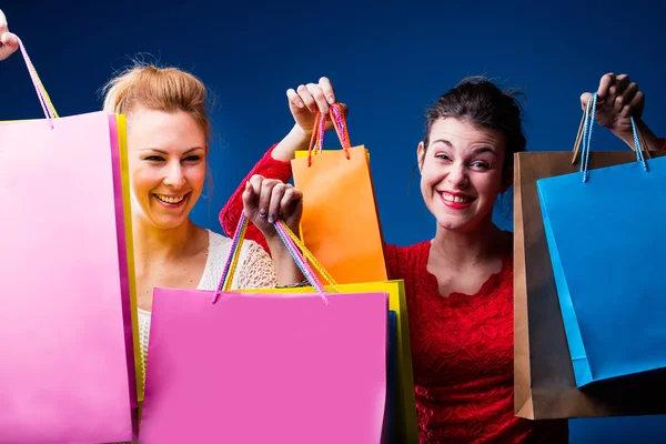 Femmes faisant du shopping avec beaucoup de sacs sur bleu — Photo