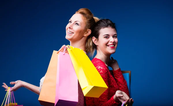 Kvinnor shopping med massor av väskor på blå — Stockfoto