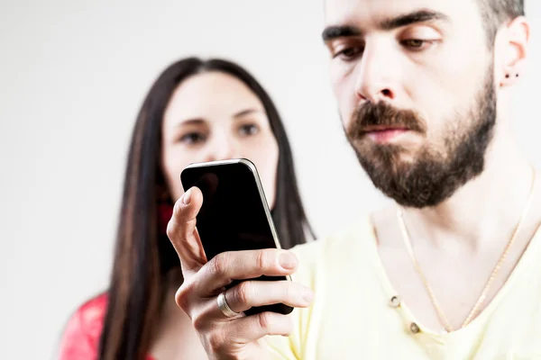 Vrouw teleurgesteld over zijn man op zijn mobiel — Stockfoto