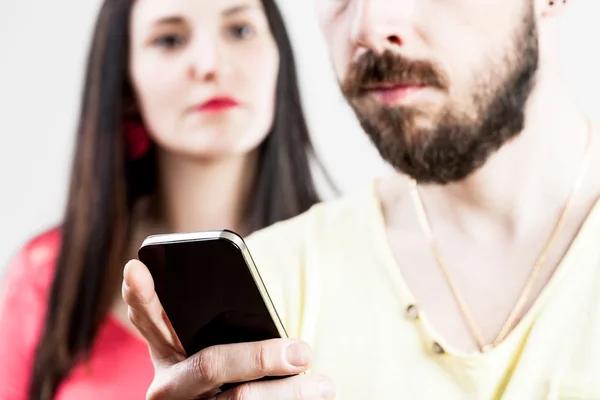 Žena zklamaná jeho člověka na jeho mobil — Stock fotografie