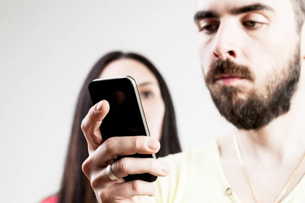 Mulher decepcionado com seu homem em seu celular — Fotografia de Stock