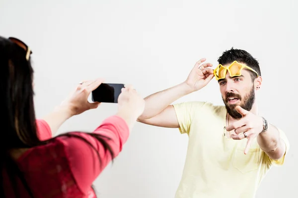 Thrilled couple taking mobile photographs and selfies — Stock Photo, Image