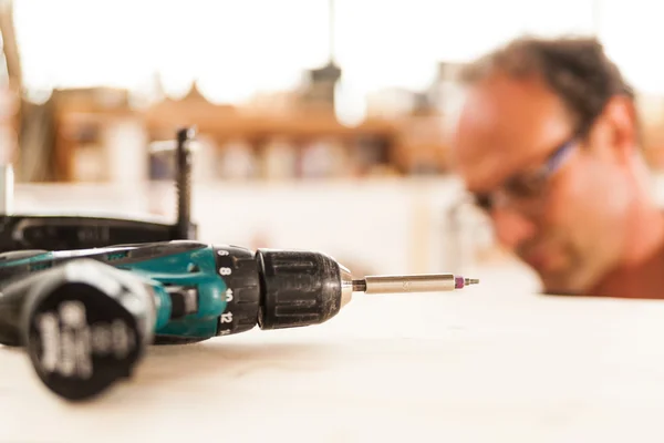 Fastener drive in focus and woodworker on background — Stock Photo, Image