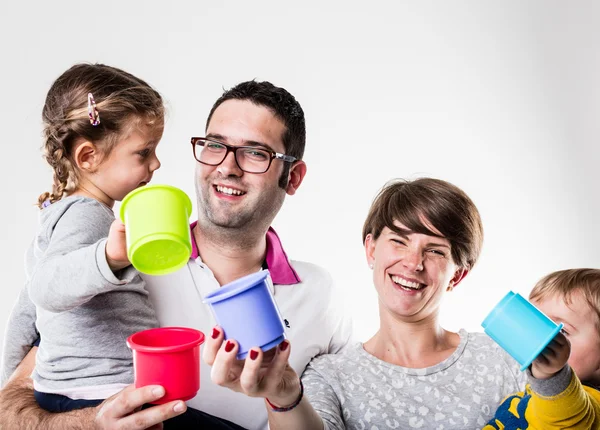 Happy family laughing with colorful toys — Stock Photo, Image