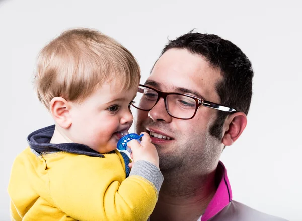 Vader kijken naar zijn zoon zijn fopspeen zuigen — Stockfoto