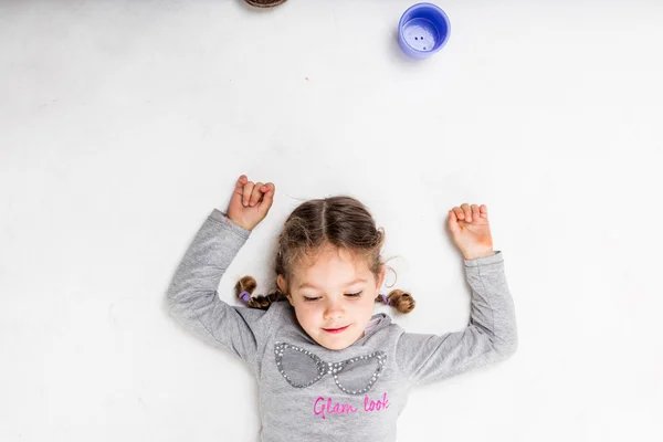 Niña sobre un fondo blanco ligeramente sucio — Foto de Stock