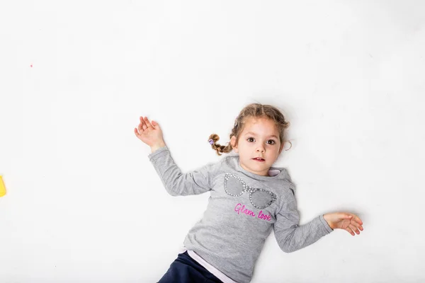 Menina em um fundo branco ligeiramente sujo — Fotografia de Stock