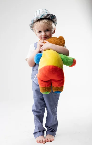 Pequeno bebê com chapéu abraçando seu ursinho de pelúcia — Fotografia de Stock