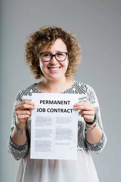 Mujer rizada sonriente sosteniendo un contrato de trabajo premanente — Foto de Stock