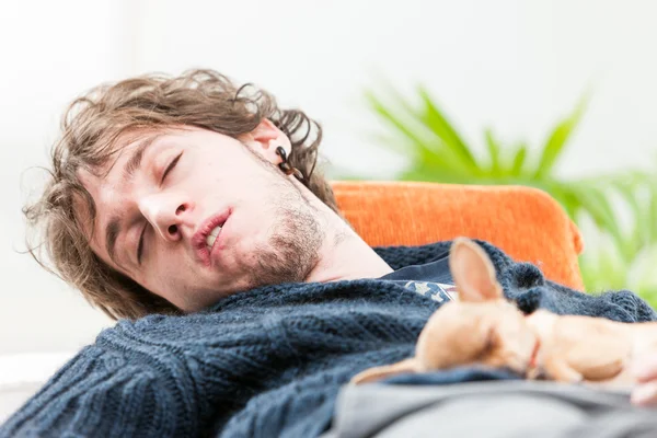 Young man sleeping with his dog on his chest — Stock Photo, Image